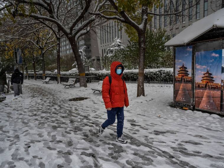 Persona camina por la nieve que hay en las calles de Beijing