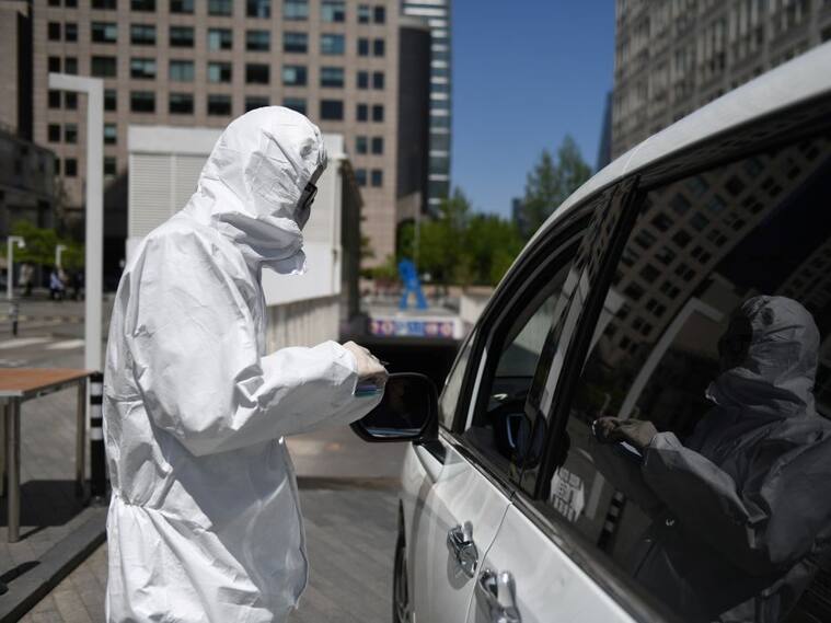El trabajador de un estacionamientos utiliza un traje de protección en Pekín