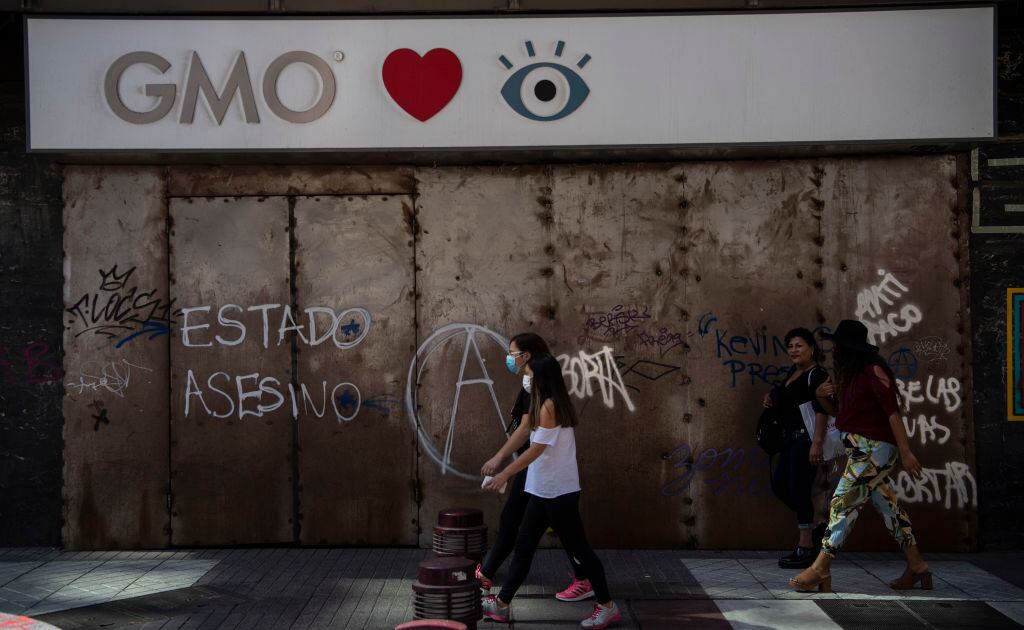 Una mujer camina por la ciudad de Santiago utilizando una máscara por el Covid-19