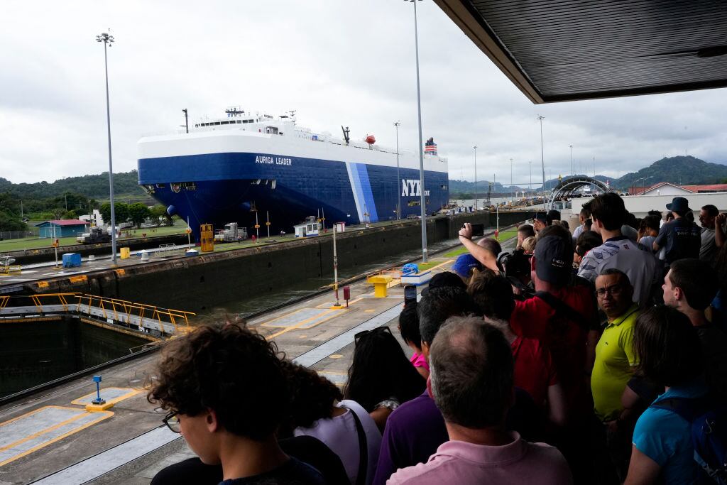 Turistas ven el paso de un barco de carga por el Canal de Panamá en ese país de Centroamérica