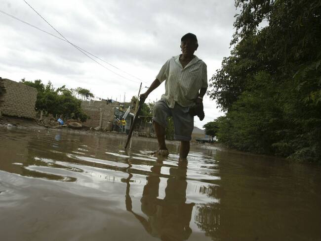 Hombre camina en el agua por fuertes lluvias y desborde de ríos en Bolivia
