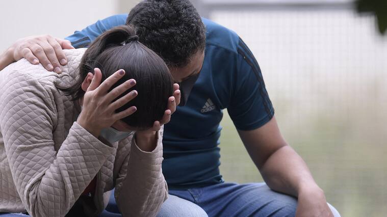 Relatives of a victim wait outside the Legal Medicine Institute of Passos, Minas Gerais State, Brazil, on January 9, 2022, a day after a large rock fragment broke off a ravine and plunged onto several tourist boats leaving ten people dead at the nearby canyons of Furnas Lake. - Ten people died when a cliff collapsed onto tourist boats on a lake in Brazil, officials said Sunday after the bodies of two missing people were found. (Photo by Douglas MAGNO / AFP) (Photo by DOUGLAS MAGNO/AFP via Getty Images)