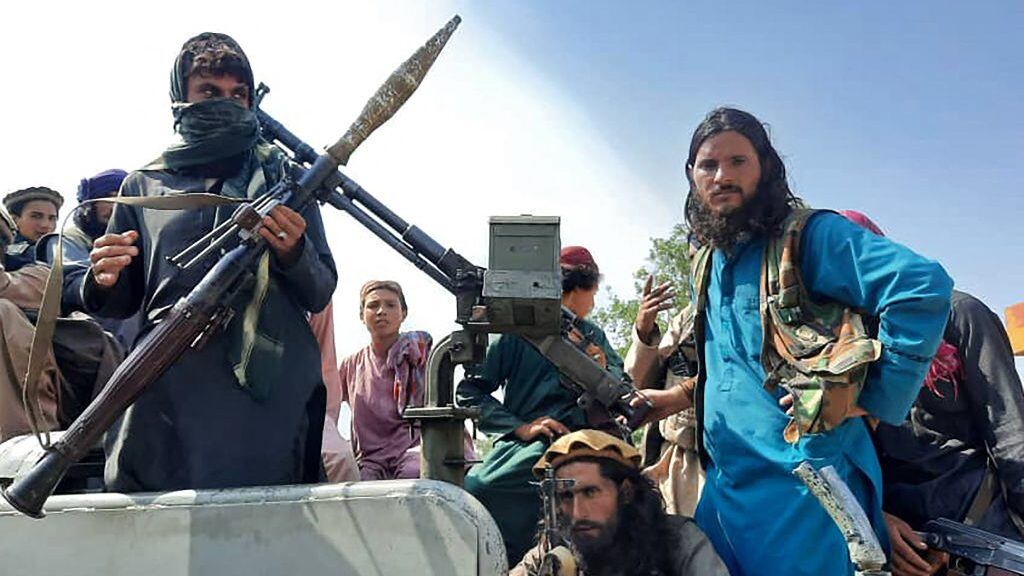 TOPSHOT - Taliban fighters sit over a vehicle on a street in Laghman province on August 15, 2021. (Photo by - / AFP) (Photo by -/AFP via Getty Images)