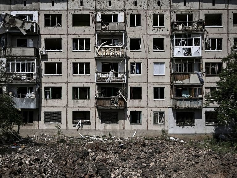 A picture shows a crater in front of a damaged apartment building after a missile strike in the city of Soledar, in the eastern Ukrainian region of Donbas on June 4, 2022. - Russian artillery is slamming Ukraine's eastern Donbas region with fierce fighting over the city of Severodonetsk, but the local governor says there was some progress in pushing back invading forces. (Photo by ARIS MESSINIS / AFP) (Photo by ARIS MESSINIS/AFP via Getty Images)