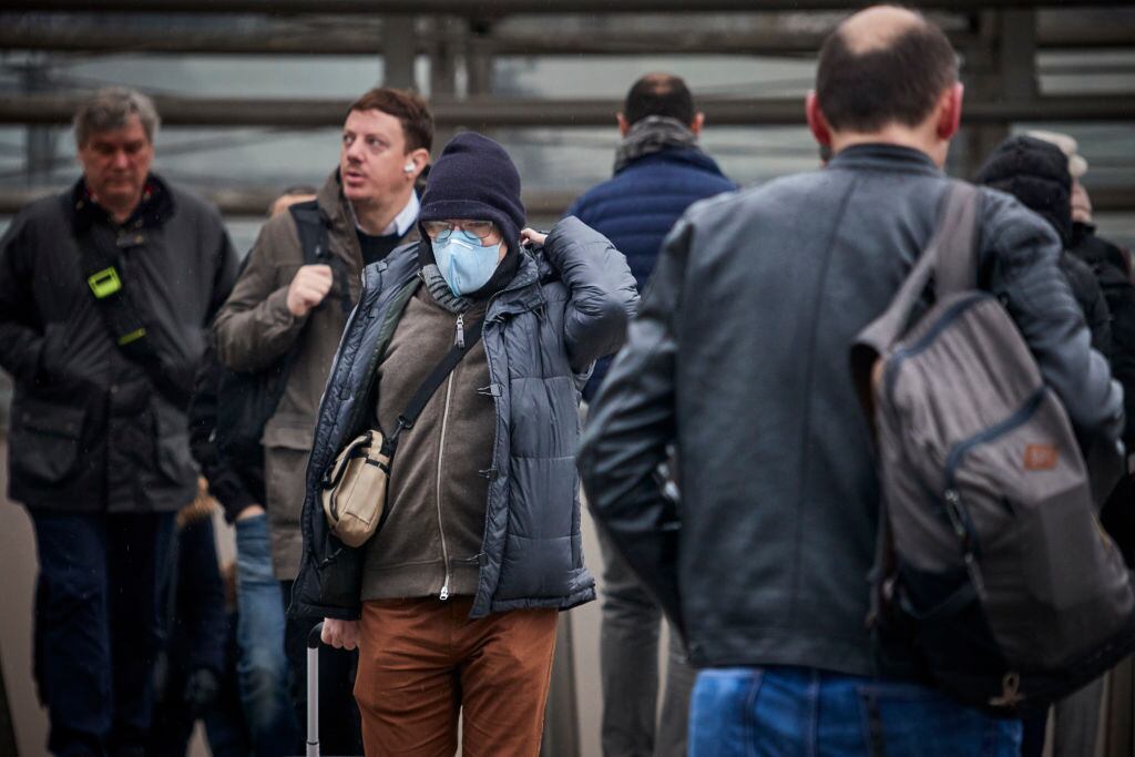 Un trabajador camina con mascarilla por la ciudad de París en Francia