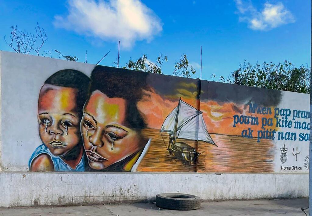 Mural sobre los riesgos de la migración irregular en una de las calles de la ciudad portuaria de Cabo Haitiano en Haití.