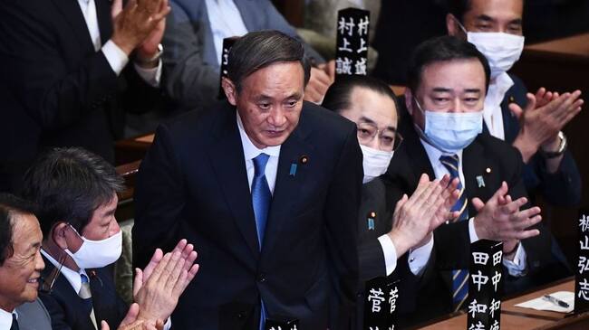 Newly elected leader of Japan's Liberal Democratic Party (LDP) Yoshihide Suga (C) is applauded after he was elected as Japan's prime minister by the Lower House of parliament in Tokyo on September 16, 2020. - Japan's parliament votes on September 16 for the country's next prime minister, with powerful cabinet secretary Yoshihide Suga all but assured the top job, as Shinzo Abe ends his record-breaking tenure. (Photo by CHARLY TRIBALLEAU / AFP) (Photo by CHARLY TRIBALLEAU/AFP via Getty Images)
