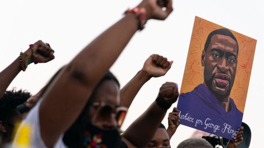 TOPSHOT - People raise their fists and hold a portrait of George Floyd during a rally following the guilty verdict the trial of Derek Chauvin on April 20, 2021, in Atlanta, Georgia. - Derek Chauvin, a white former Minneapolis police officer, was convicted on April 20 of murdering African-American George Floyd after a racially charged trial that was seen as a pivotal test of police accountability in the United States. (Photo by Elijah Nouvelage / AFP) (Photo by ELIJAH NOUVELAGE/AFP via Getty Images)