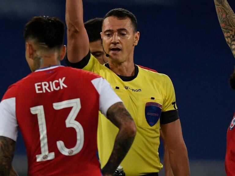 Colombian referee Wilmar Roldan shows the yellow card to Chile&#039;s Erick Pulgar (L) as he conducts the Conmebol Copa America 2021 football tournament group phase match between Argentina and Chile at the Nilton Santos Stadium in Rio de Janeiro, Brazil, on June 14, 2021. (Photo by MAURO PIMENTEL / AFP) (Photo by MAURO PIMENTEL/AFP via Getty Images)