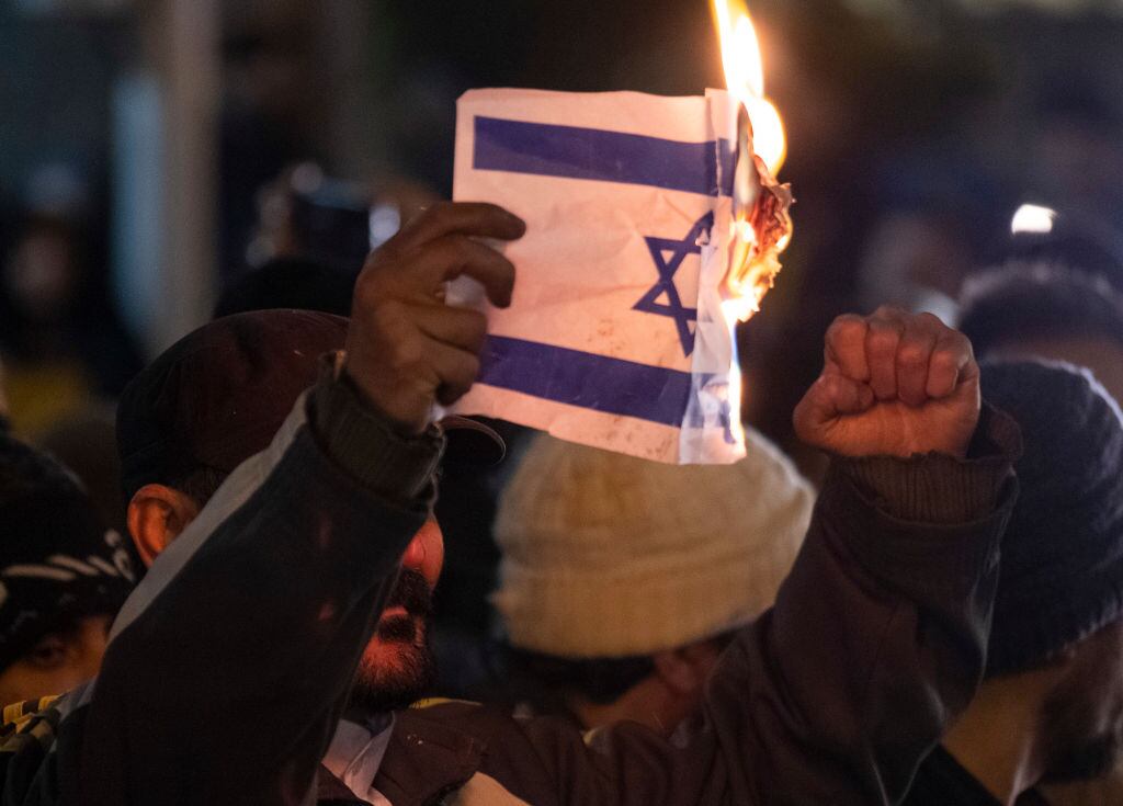 Un manifestante quema una bandera de Israel ante la embajada de Estados Unidos en la ciudad de Teherán en Irán.