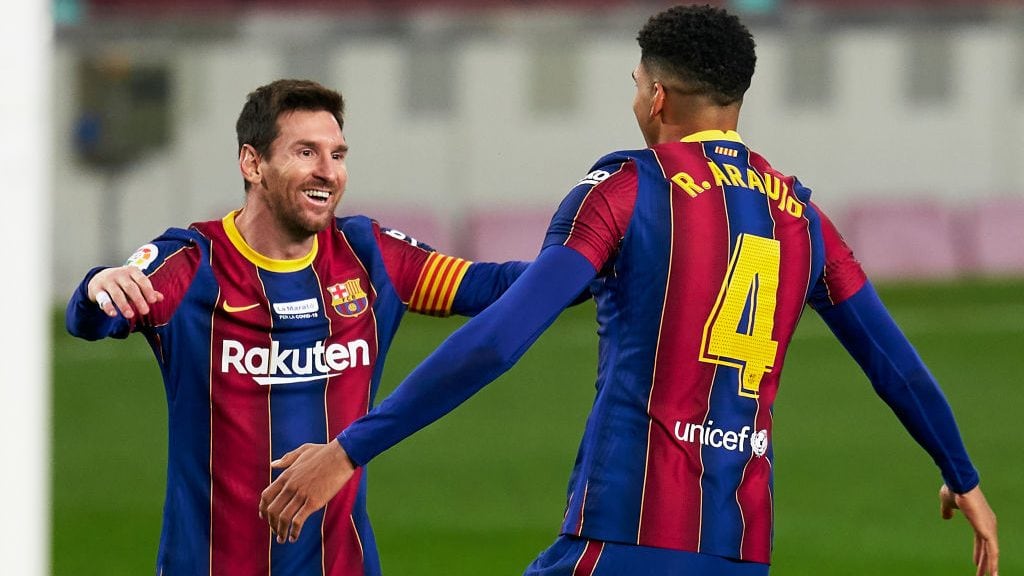 BARCELONA, SPAIN - DECEMBER 19: Ronald Araujo of FC Barcelona celebrates after scoring his team's second goal with his teammate Lionel Messi during the La Liga Santander match between FC Barcelona and Valencia CF at Camp Nou on December 19, 2020 in Barcelona, Spain. Sporting stadiums around Spain remain under strict restrictions due to the Coronavirus Pandemic as Government social distancing laws prohibit fans inside venues resulting in games being played behind closed doors. (Photo by Pedro Salado/Quality Sport Images/Getty Images)