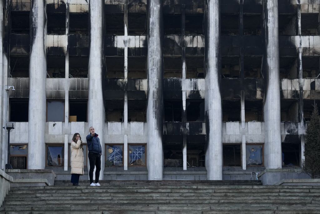Personas observan el daño al edificio de la gobernación en Almaty