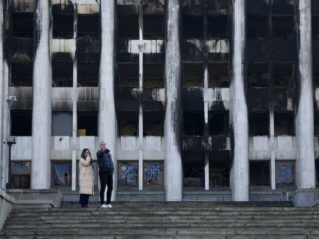 Personas observan el daño al edificio de la gobernación en Almaty