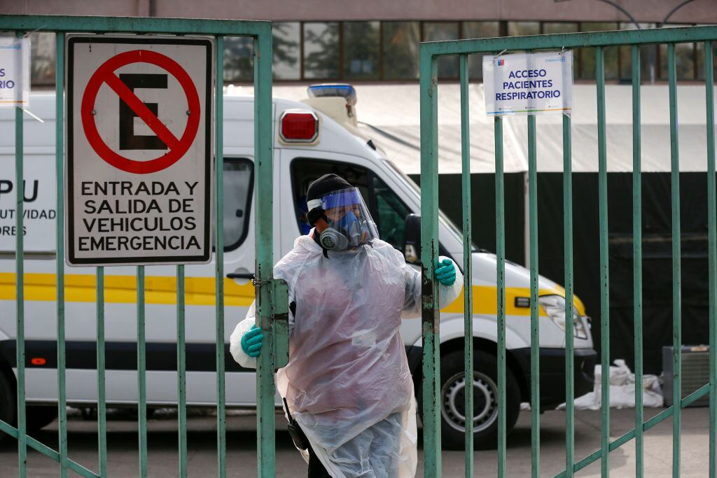 A health worker closes the gate at San Jose hospital where COVID-19 tests are carried out, in Santiago, on June 15, 2020, amid the novel coronavirus pandemic. - Chile renewed for three months the "constitutional state of emergency due to catastrophe", which leaves public order in the hands of the military and establishes a night curfew. An official report on the eve showed 6,938 new infections and 222 deaths, bringing the total to 174,293 infected and 3,323 dead. (Photo by JAVIER TORRES / AFP) (Photo by JAVIER TORRES/AFP via Getty Images)