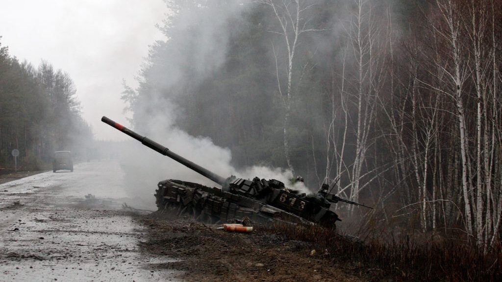 TOPSHOT - Smoke rises from a Russian tank destroyed by the Ukrainian forces on the side of a road in Lugansk region on February 26, 2022. - Russia on February 26 ordered its troops to advance in Ukraine "from all directions" as the Ukrainian capital Kyiv imposed a blanket curfew and officials reported 198 civilian deaths. (Photo by Anatolii Stepanov / AFP) (Photo by ANATOLII STEPANOV/AFP via Getty Images)