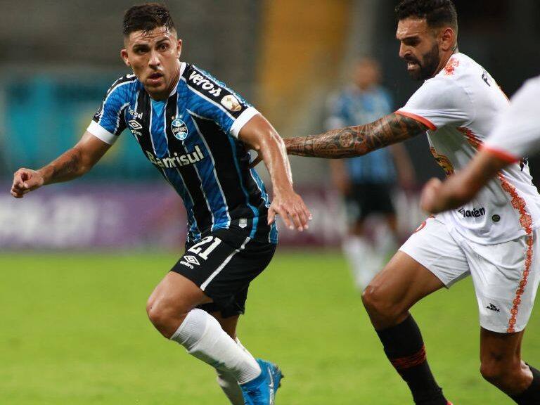 Peru's Ayacucho, Uruguayn Guillermo Firpo (R) and Brazil's Gremio Chilean Cesar Pinares vie for the ball during their Copa Libertadores football tournament second round match at the Arena do Gremio stadium in Porto Alegre, on March 10, 2021. (Photo by SILVIO AVILA / POOL / AFP) (Photo by SILVIO AVILA/POOL/AFP via Getty Images)
