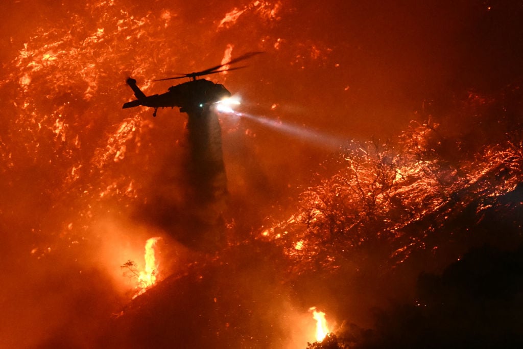 Un helicóptero combate el fuego en Palisades en los alrededores de Los Angeles en el estado de California en Estados Unidos