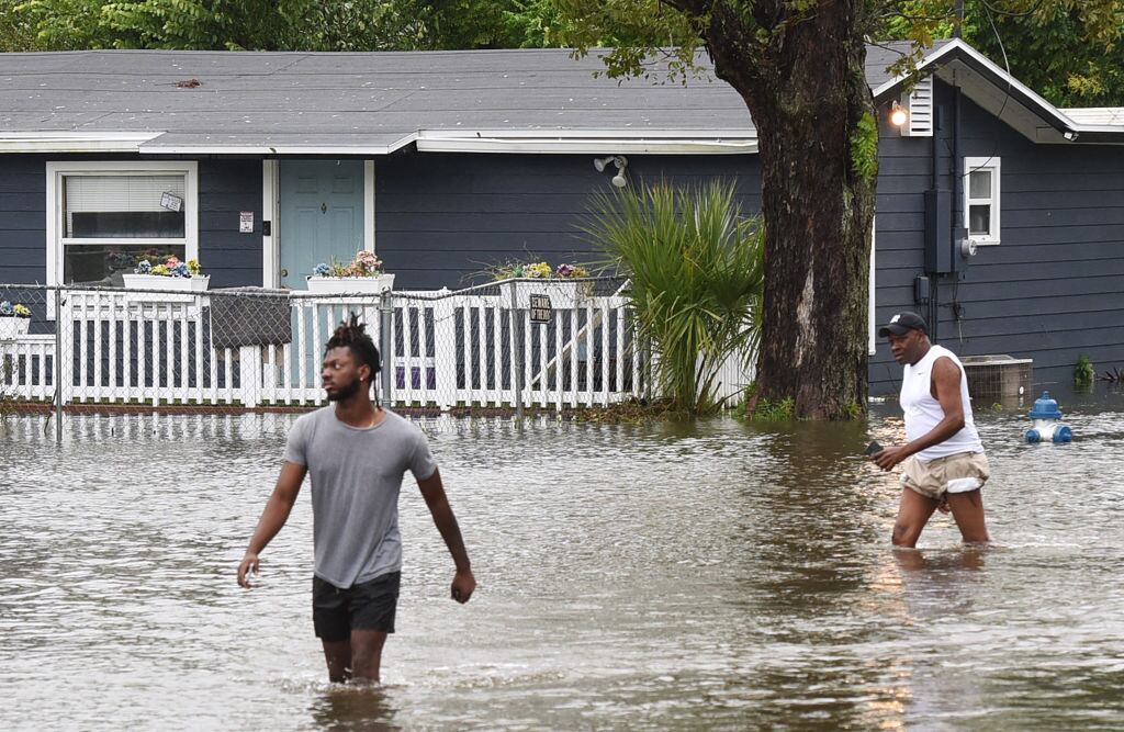 Dos hombres caminan por las calles inundadas en Orlando de Florida