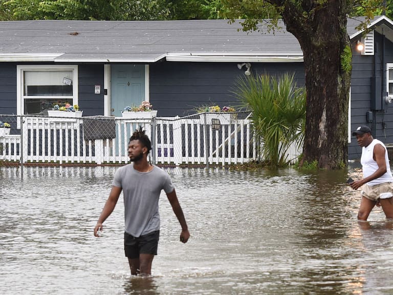 Dos hombres caminan por las calles inundadas en Orlando de Florida