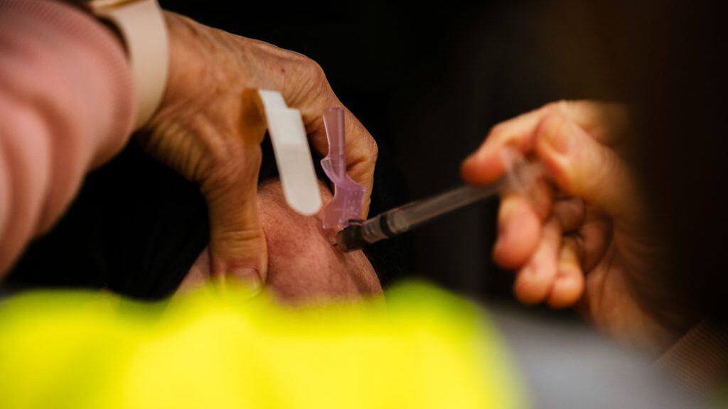 LOUISVILLE, KY - JANUARY 04: A health worker administers a vaccine to a patient in their vehicle during the first day of mass Moderna COVID-19 vaccinations in Broadbent Arena at the Kentucky State Fair and Exposition Center on January 4, 2021 in Louisville, Kentucky. Monday marked the first day of mass, drive-in vaccinations in the state. Healthcare workers are the main focus of vaccinations, as mandated by the federal government. (Photo by Jon Cherry/Getty Images)