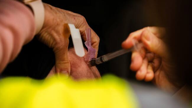 LOUISVILLE, KY - JANUARY 04: A health worker administers a vaccine to a patient in their vehicle during the first day of mass Moderna COVID-19 vaccinations in Broadbent Arena at the Kentucky State Fair and Exposition Center on January 4, 2021 in Louisville, Kentucky. Monday marked the first day of mass, drive-in vaccinations in the state. Healthcare workers are the main focus of vaccinations, as mandated by the federal government. (Photo by Jon Cherry/Getty Images)