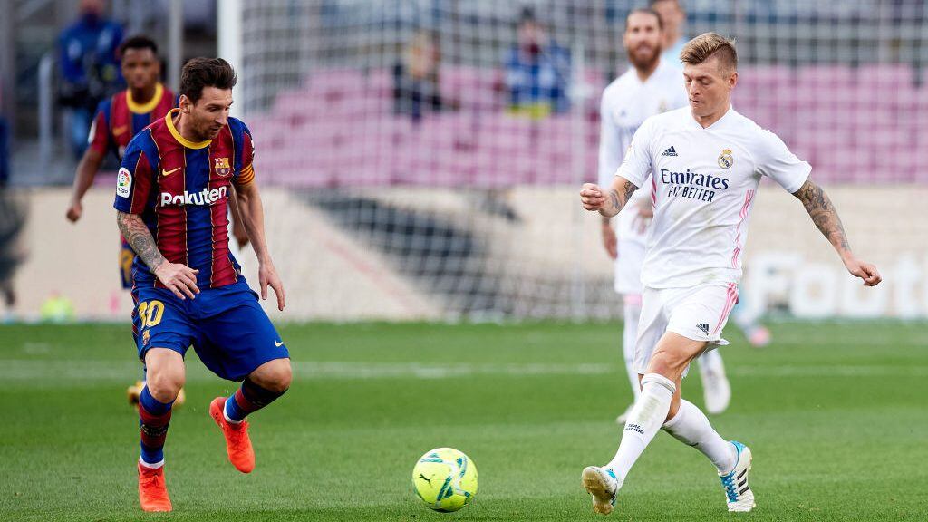 BARCELONA, SPAIN - OCTOBER 24: Lionel Messi of FC Barcelona competes for the ball with Toni Kroos of Real Madrid CF during the La Liga Santander match between FC Barcelona and Real Madrid at Camp Nou on October 24, 2020 in Barcelona, Spain. Sporting stadiums around Spain remain under strict restrictions due to the Coronavirus Pandemic as Government social distancing laws prohibit fans inside venues resulting in games being played behind closed doors. (Photo by Alex Caparros/Getty Images)