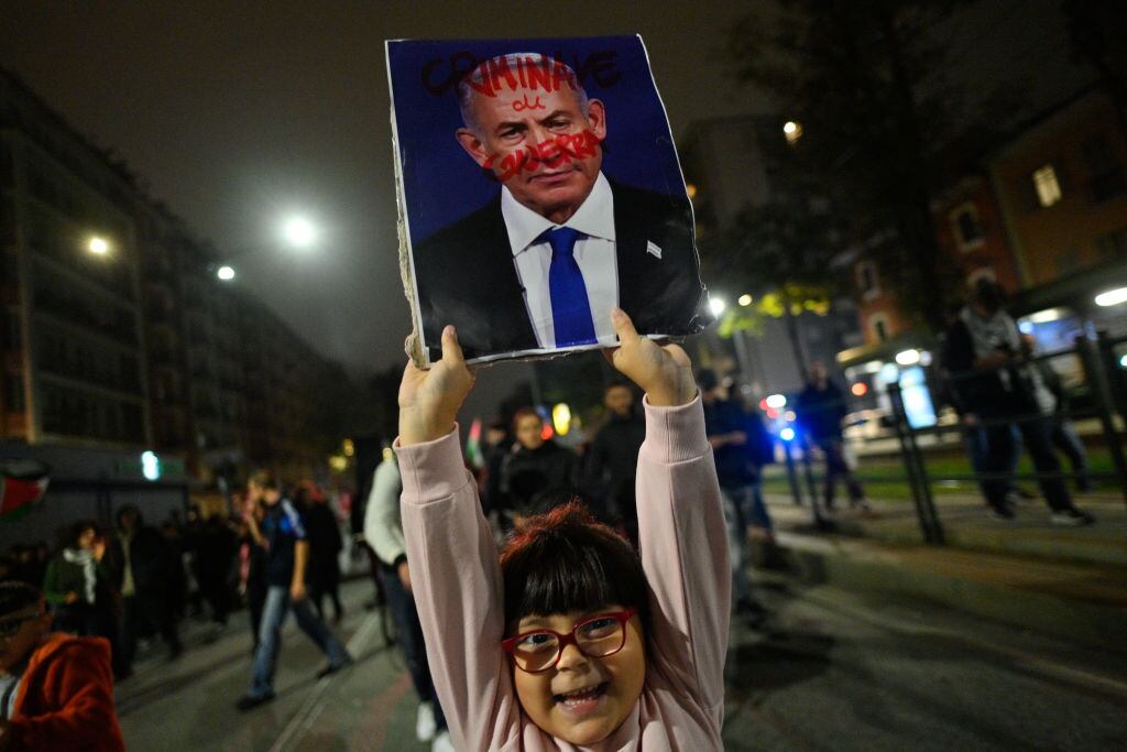 Una niña en Italia porta un cartel que muestra ensangrentado al primer ministro de Israel, Benjamin Netanyahu, por los ataques contra la Franja de Gaza