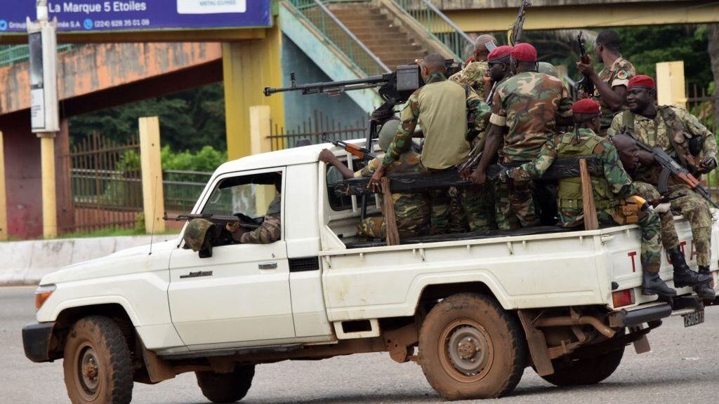 Members of the Armed Forces of Guinea drive through the central neighbourhood of Kaloum in Conakry on September 5, 2021 after sustainable gunfire was heard. - Gunfire was heard in Conkary in the morning and troops were seen on the streets, witnesses told AFP. There was no immediate explanation for the incidents in Conakry's Kaloum peninsula, where the presidency, various institutions and offices are located. (Photo by CELLOU BINANI / AFP) (Photo by CELLOU BINANI/AFP via Getty Images)
