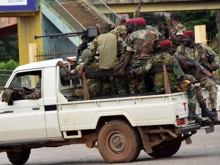 Members of the Armed Forces of Guinea drive through the central neighbourhood of Kaloum in Conakry on September 5, 2021 after sustainable gunfire was heard. - Gunfire was heard in Conkary in the morning and troops were seen on the streets, witnesses told AFP. There was no immediate explanation for the incidents in Conakry's Kaloum peninsula, where the presidency, various institutions and offices are located. (Photo by CELLOU BINANI / AFP) (Photo by CELLOU BINANI/AFP via Getty Images)