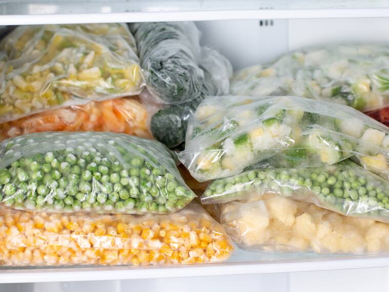 Plastic bags with deep frozen vegetables in refrigerator