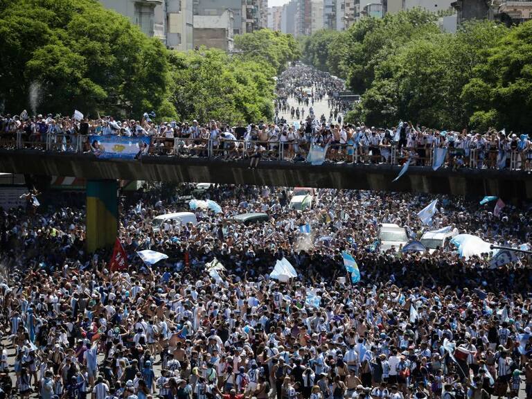 Fans of Argentina wait for the bus with Argentina's players to pass through an avenue to celebrate after winning the Qatar 2022 World Cup tournament in Buenos Aires on December 20, 2022. - Millions of ecstatic fans are expected to cheer on their heroes as Argentina's World Cup winners led by captain Lionel Messi began their open-top bus parade of the capital Buenos Aires on Tuesday following their sensational victory over France. (Photo by Emiliano Lasalvia / AFP) (Photo by EMILIANO LASALVIA/AFP via Getty Images)