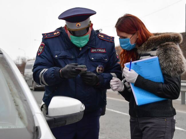 Un policía controla a una automovilista por el Covid-19 en Rusia