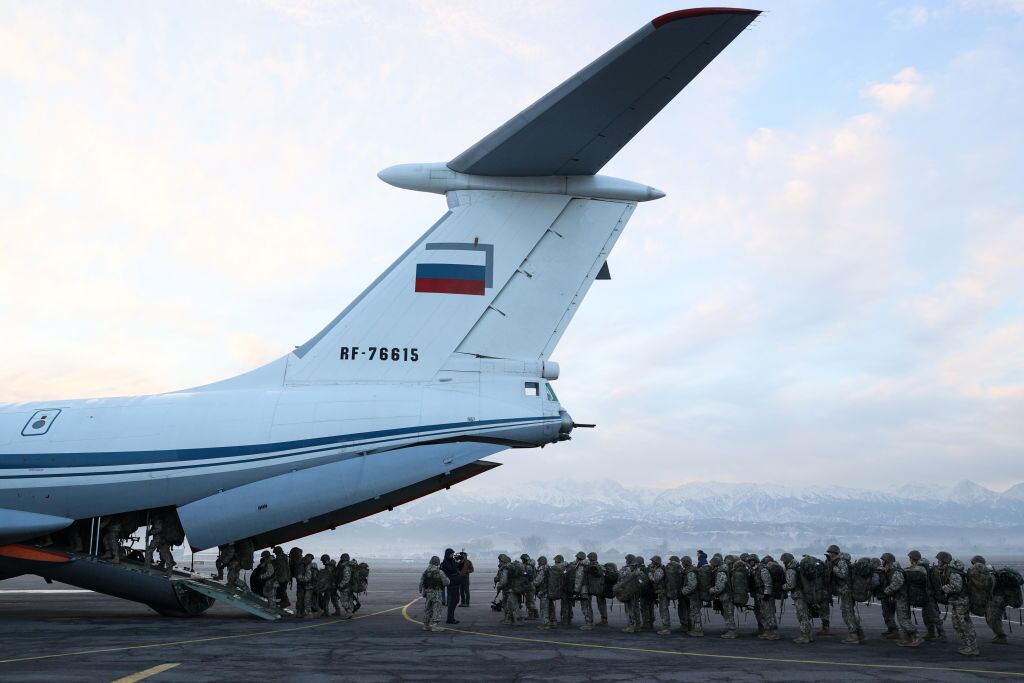 Soldados rusos suben a un avión y salen desde la ciudad kazaja de Almaty