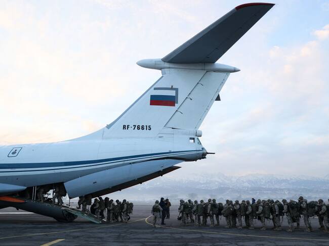 Soldados rusos suben a un avión y salen desde la ciudad kazaja de Almaty