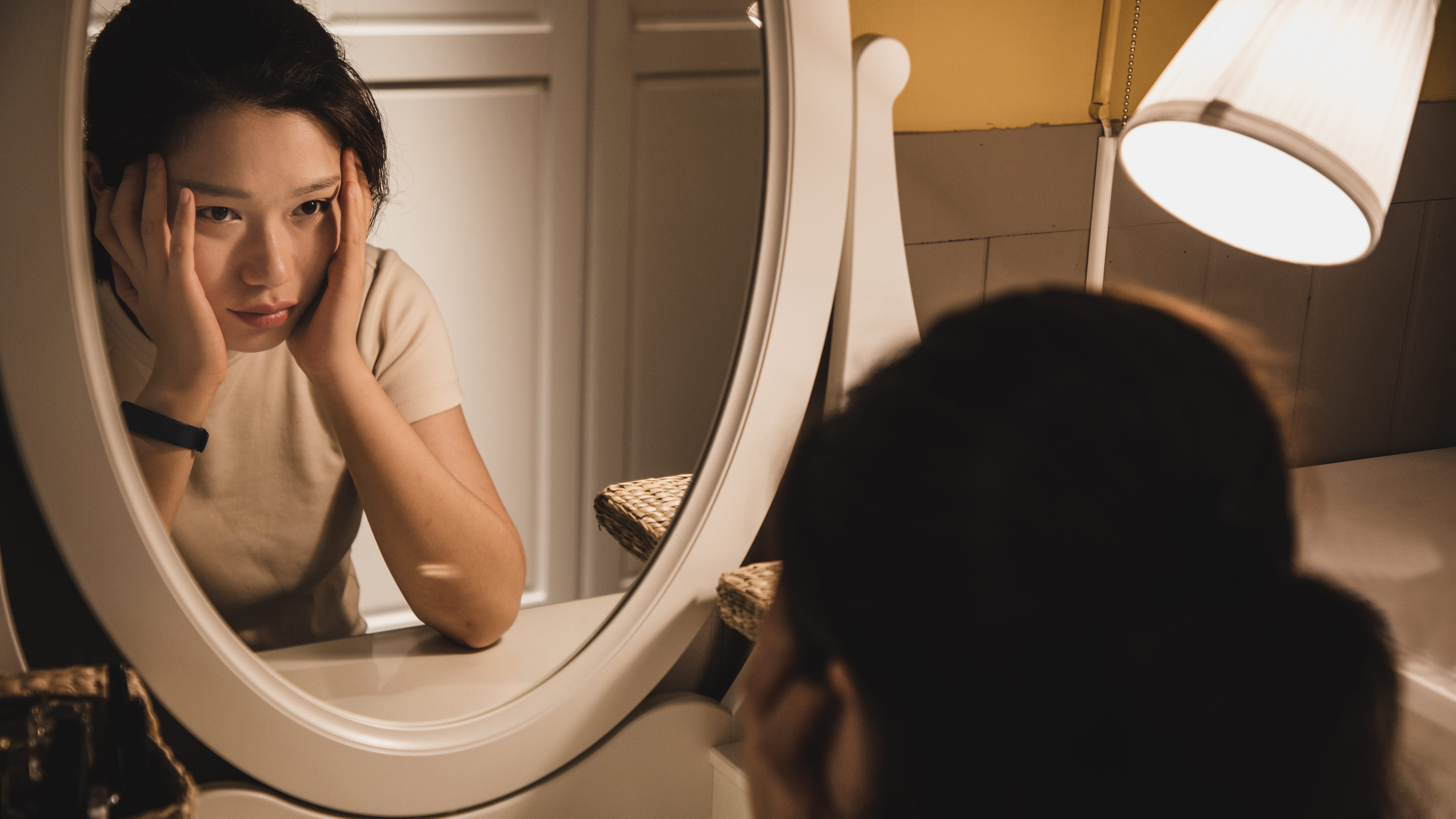 Asian woman sitting in front of the dressing table feeling depressed