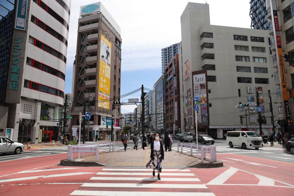 Una mujer con mascarilla recorre el barrio de Ikebukuro en Tokio