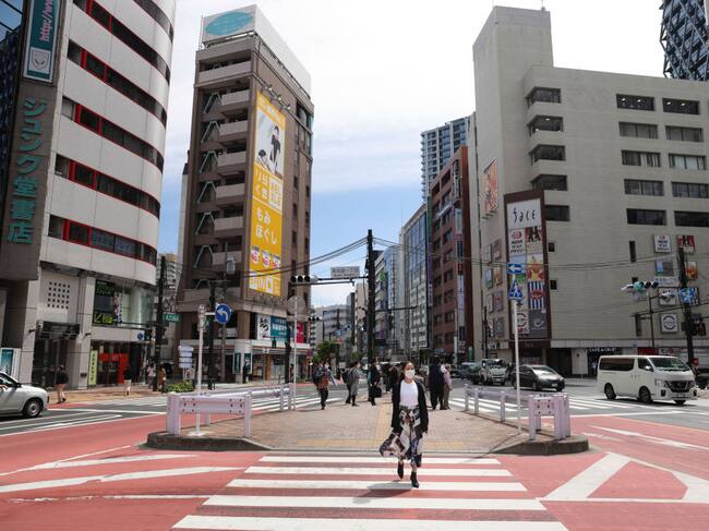 Una mujer con mascarilla recorre el barrio de Ikebukuro en Tokio
