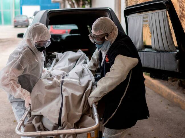 Trabajadores de una funeraria llevan a una víctima del coronavirus