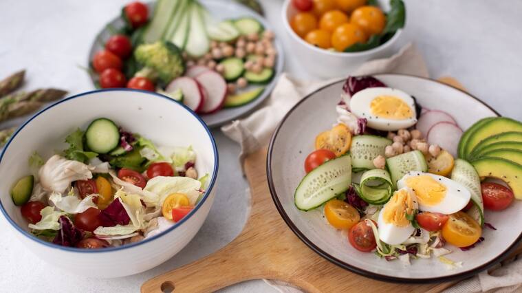 Healthy detox dish with egg, avocado, quinoa, spinach, fresh tomato, green peas and broccoli on white wooden background, top view