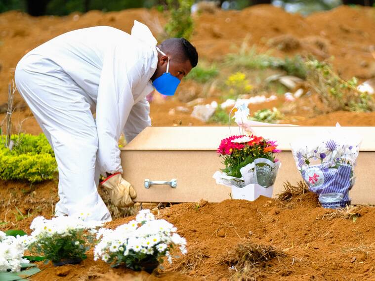 Un trabajador entierra a una víctima del Covid-19 en el cementerio Vila Formosa de Sao Paulo