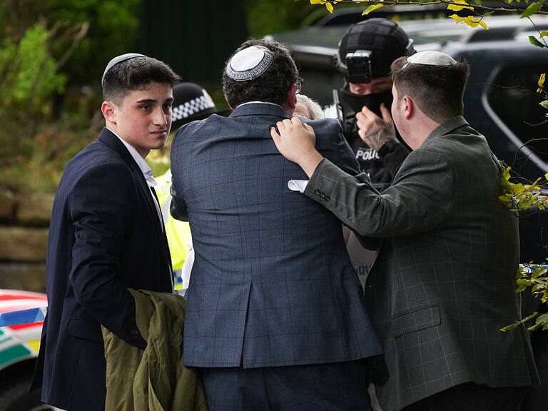 MANCHESTER, ENGLAND - OCTOBER 2: Members of the public and congregants seen as Police and other emergency responders attend the Heaton Park Hebrew Congregation Synagogue, where multiple were injured after stabbing and car attack on Yom Kippur, on October 2, 2025 in the Crumpsall suburb of Manchester, England. Greater Manchester Police said they were called to the scene shortly after 9:30 AM, when a witness said the assailant drove a car at people and then stabbed someone. Police then shot the suspected attacker. (Photo by Christopher Furlong/Getty Images)