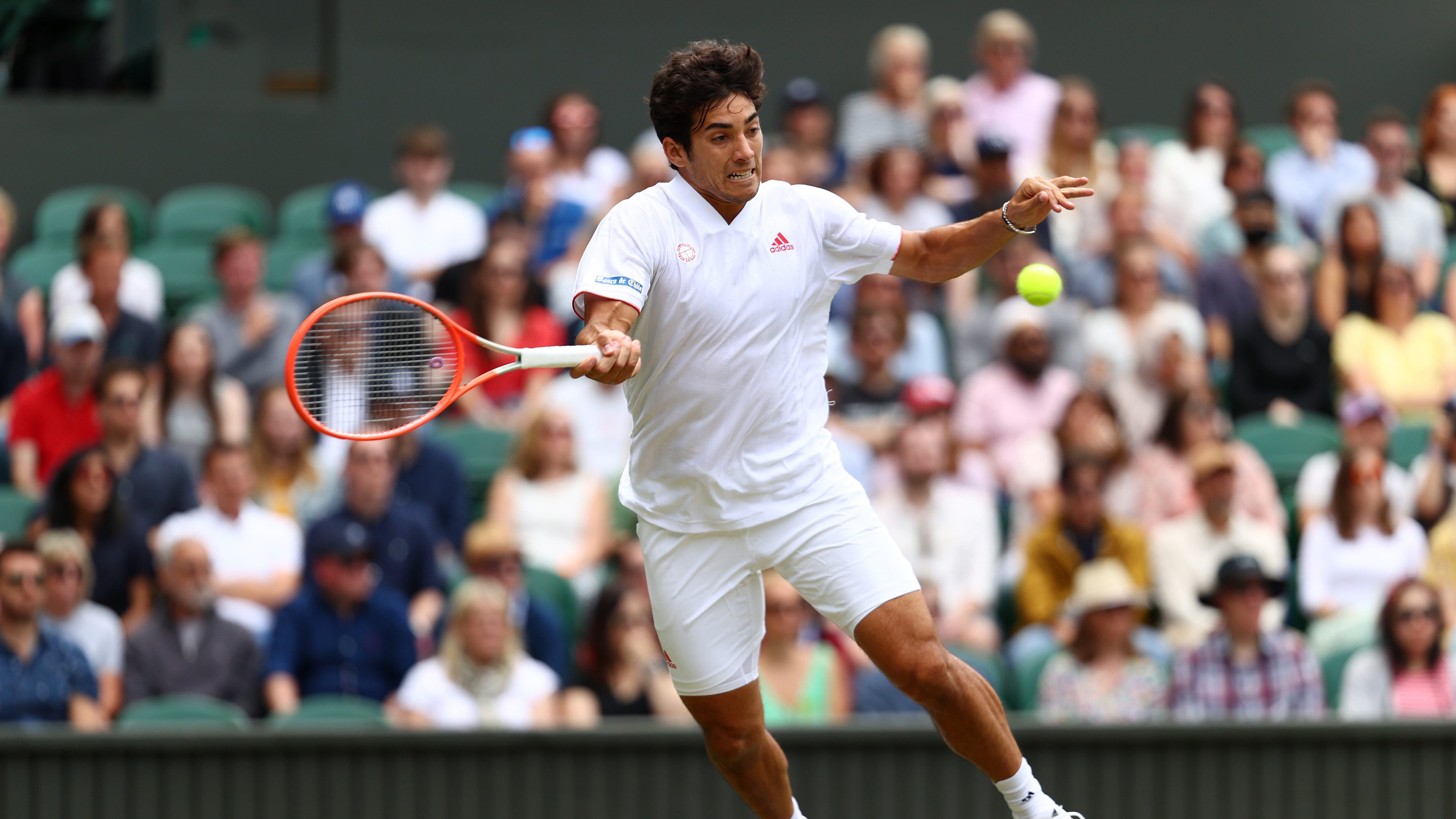 LONDON, ENGLAND - JULY 05: Cristian Garin of Chile stretches to play a forehand in his Men's Singles Fourth Round match against Novak Djokovic of Serbia during Day Seven of The Championships - Wimbledon 2021 at All England Lawn Tennis and Croquet Club on July 05, 2021 in London, England. (Photo by Julian Finney/Getty Images)