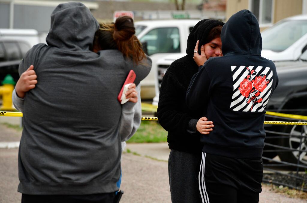 Familiares de las víctimas lloran afuera de la escena del crimen en Colorado