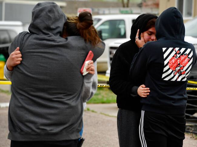 Familiares de las víctimas lloran afuera de la escena del crimen en Colorado