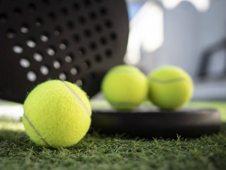 Paddle tennis rackets and ball on turf