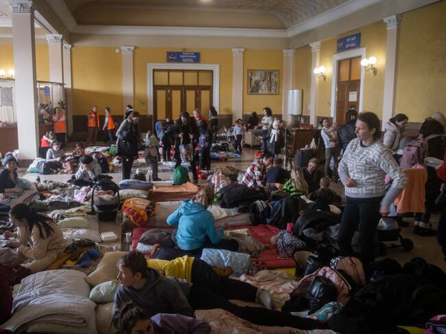 Personas duermen en la estación de trenes de Lviv para abandonar Ucrania