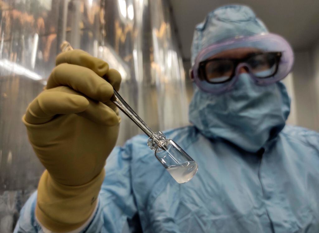 Trabajador de la ciencia cubano muestra una dosis de la vacuna Soberana II