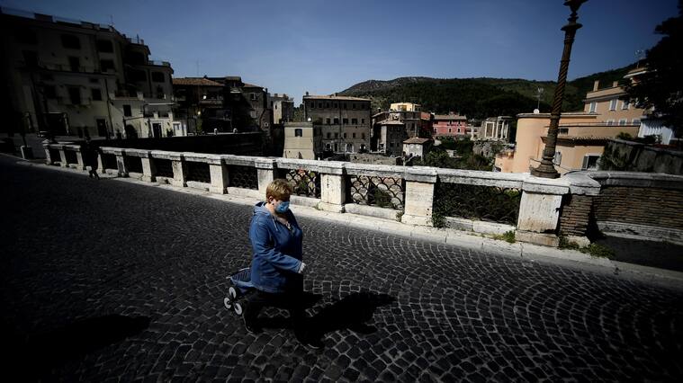 A woman wearing a face mask walks on an empty Gregoriano bridge in central Tivoli on April 17, 2020, during a lockdown aimed at curbing the spread of the COVID-19 pandemic, caused by the novel coronavirus. - The coronavirus lockdown is putting tourist towns across Italy at risk, such as Tivoli which is famed for its beautiful gardens. (Photo by Filippo MONTEFORTE / AFP) (Photo by FILIPPO MONTEFORTE/AFP via Getty Images)