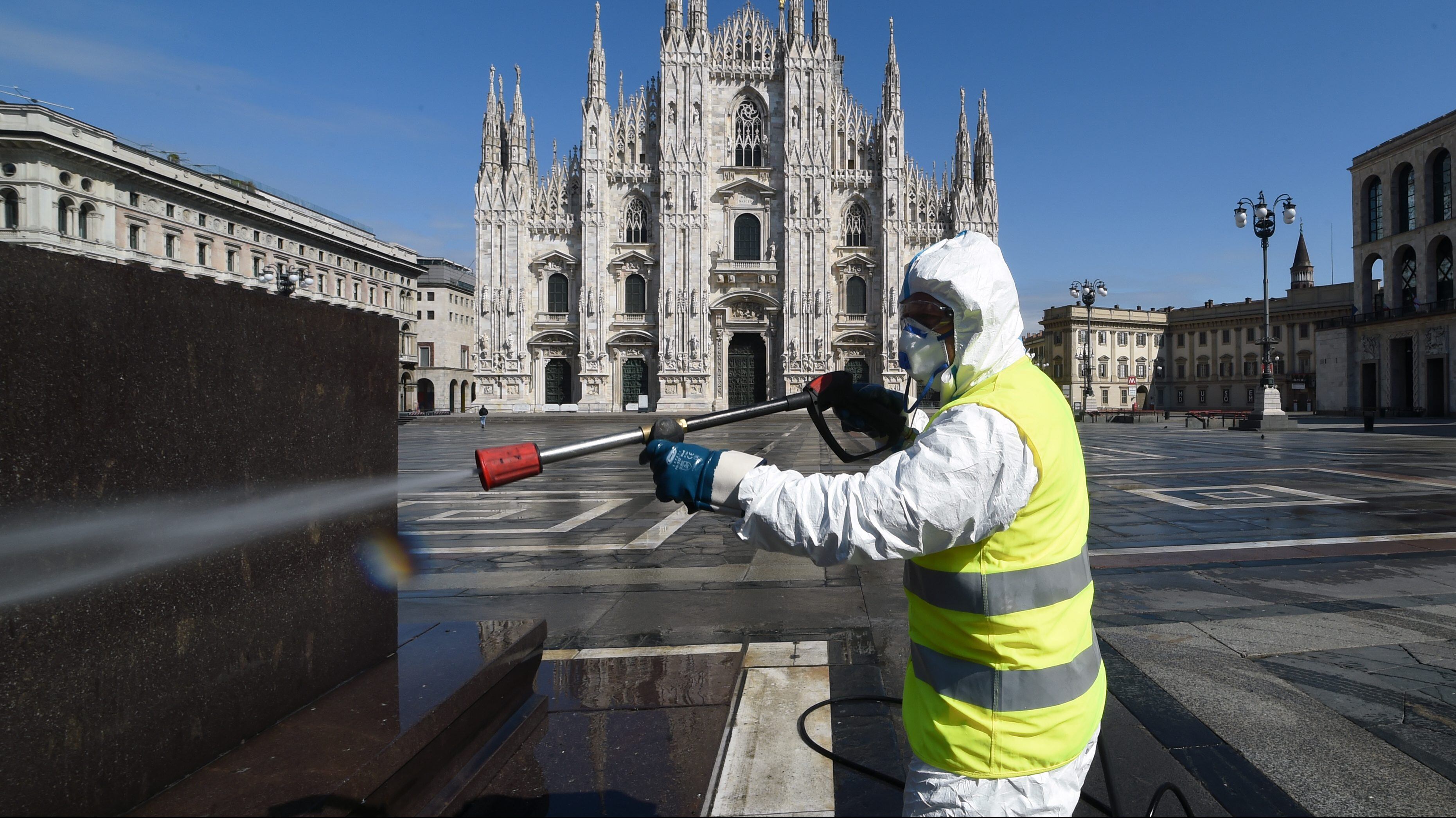 Un trabajador sanitiza una plaza de Milán