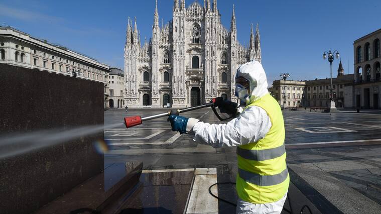 Un trabajador sanitiza una plaza de Milán